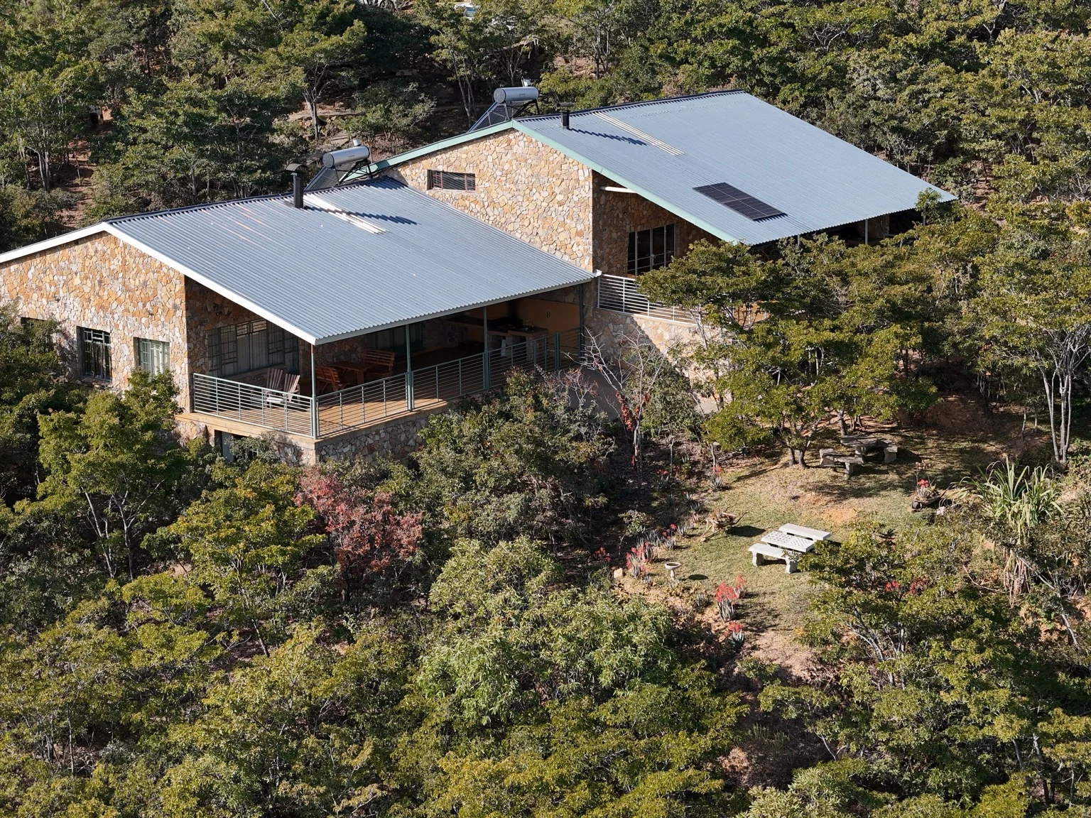 Two stone Zumbane lodges set among the trees in Nyanga
