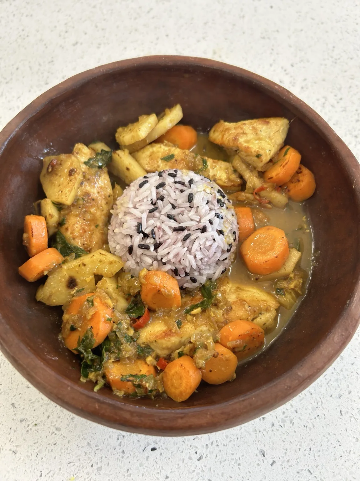 Chicken dish served in a rustic clay bowl